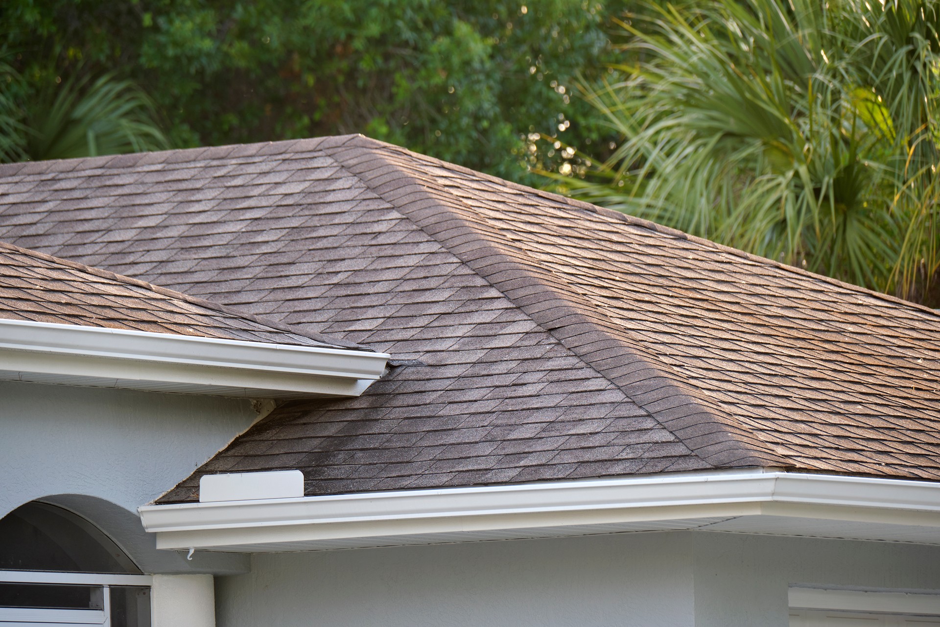 Closeup of house roof top covered with asphalt or bitumen shingles. Waterproofing of new building